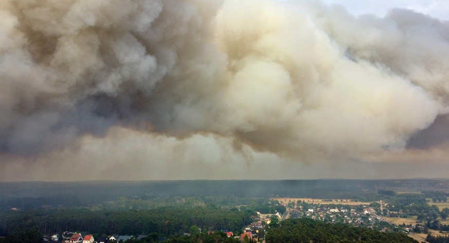 Dunkle Rauchwolken hängen aufgrund des Waldbrandes über Beelitz, Brandenburg. 