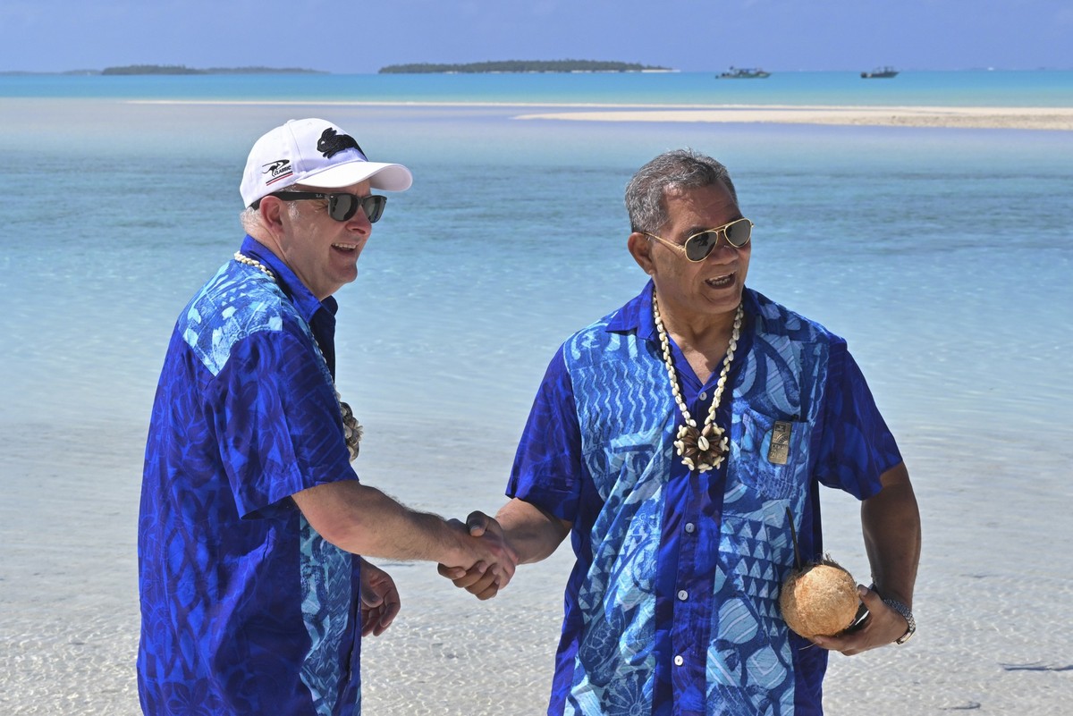 09.11.2023, Cookinseln, Aitutaki: Anthony Albanese (l), Premierminister von Australien, und Kausea Natano, Premierminister von Tuvalu, schütteln sich auf One Foot Island die Hände, nachdem sie an der ...