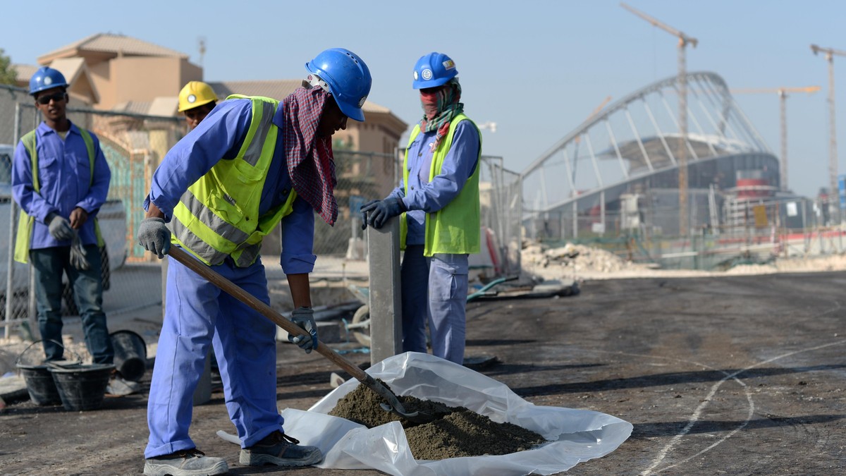 Gastarbeiter aus Indien und Bangladesch bringen am 11.01.2017 an einer Straße vor dem Khalifa-Stadion in Doha, Katar, einen Bordstein an. Foto: Andreas Gebert/dpa