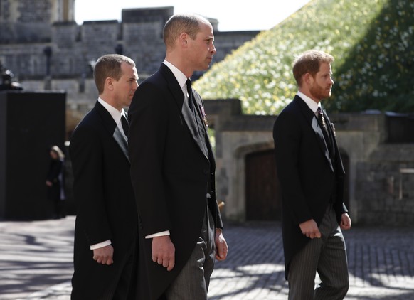 Britain's Prince Harry, right, Prince William, Peter Phillips, left, follow the coffin in a ceremonial procession for the funeral of Britain's Prince Philip inside Windsor Castle in Windsor, England S ...
