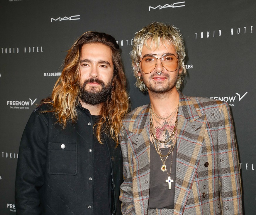 22.10.2021, Berlin: Tom Kaulitz (l) und Bruder Bill Kaulitz kommen zum Tokio Hotel-Event in Berlin. Am Freitag ver