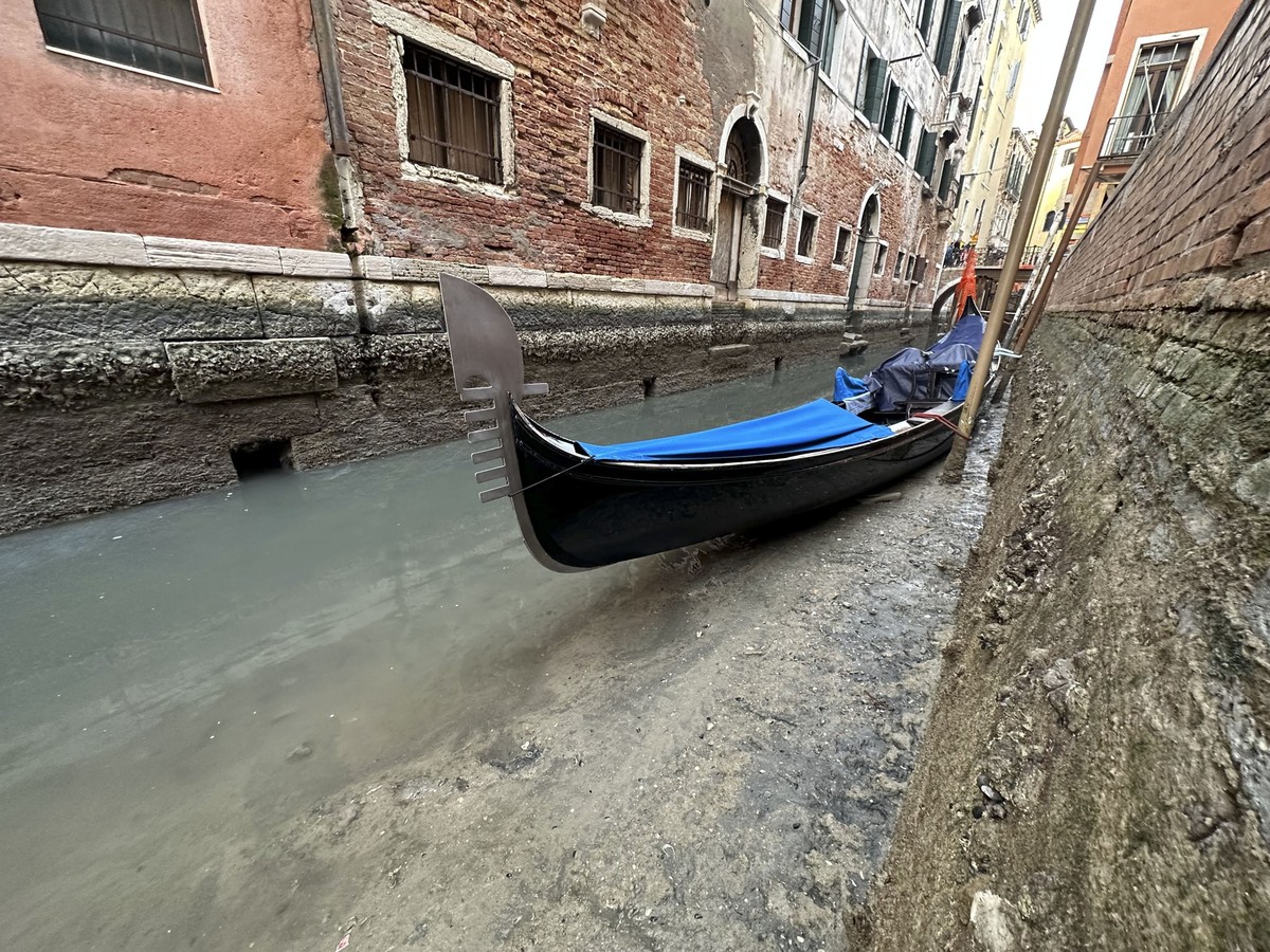 20.02.2023, Italien, Venedig: Eine Gondel liegt bei Ebbe an einem Kanal. Die Dürre im Norden Italiens nimmt nach Einschätzung von Umweltschützern immer alarmierendere Ausmaße an. Foto: Luigi Costantin ...