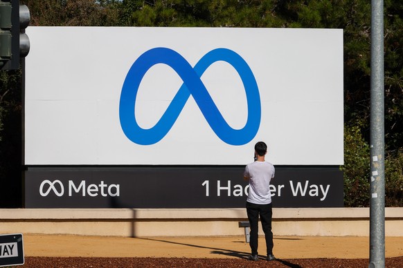 MENLO PARK, CA - OCTOBER 28: People take photos of the new &quot;Meta&quot; sign at the One Hacker Way in Menlo Park, as Facebook changes its company name to Meta in California, United States on Octob ...