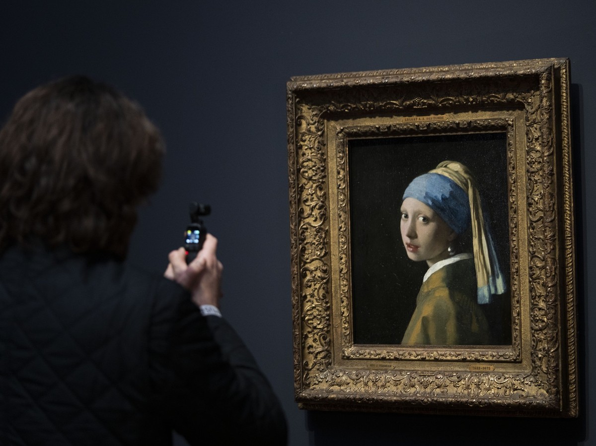 ARCHIV - 06.02.2023, Niederlande, Amsterdam: Eine Person fotografiert das Gemälde «Das Mädchen mit dem Perlenohrring» während eines Pressetermins für die Vermeer-Ausstellung im Rijksmuseum. (zu dpa &q ...