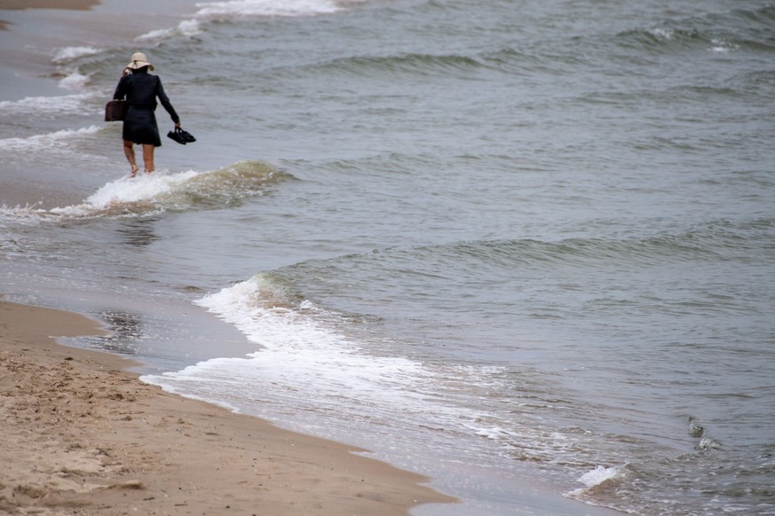 05.07.2023, Mecklenburg-Vorpommern, Usedom: Eine Frau geht bei stürmischem Wetteran an der Ostseeküste auf der Insel Usedom. Der Seewetterdienst Hamburg hat eine amtliche Sturm-Warnung für die deutsch ...