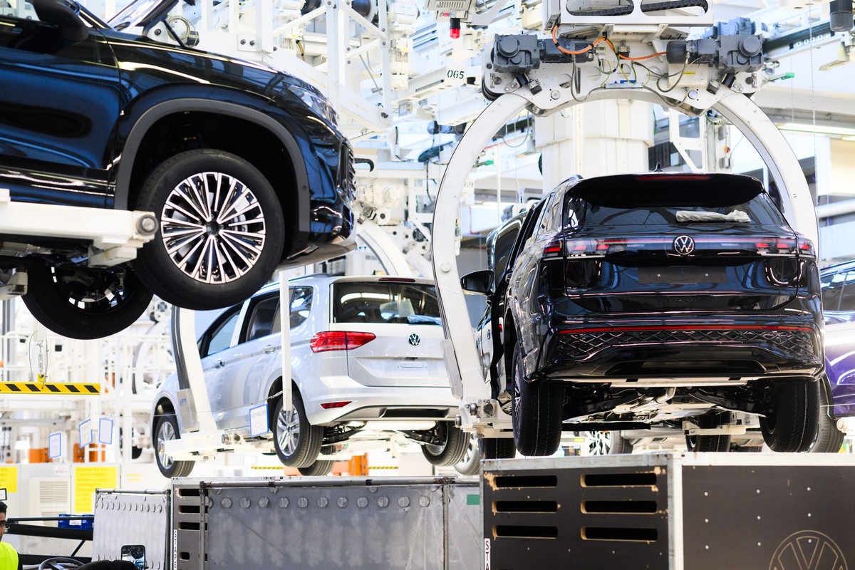 ARCHIV - 07.03.2025, Niedersachsen, Wolfsburg: Neuwagen Volkswagen Tayron, Tiguan und Touran schweben durch das VW Stammwerk. (zu dpa: «US-Autozölle setzen Volkswagen und Zulieferer unter Druck») Foto ...