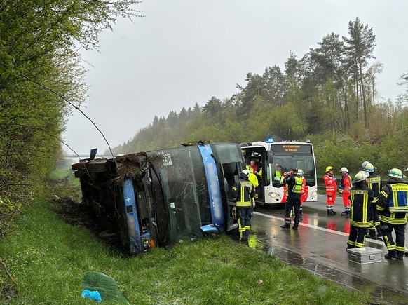 21.04.2024, Nordrhein-Westfalen, Olpe: Ein Bus liegt umgefallen am Straßenrand. Ein Reisebus mit Schülern ist am Sonntagmorgen auf der Autobahn 45 im Sauerland umgestürzt. Acht Jugendliche wurden nach ...