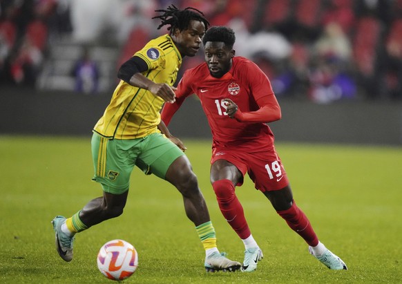 Canada&#039;s Alphonso Davies (19) moves past Jamaica&#039;s Dexter Lembikisa during the first half in the second leg of a CONCACAF Nations League soccer quarterfinal in Toronto on Tuesday, Nov. 21, 2 ...