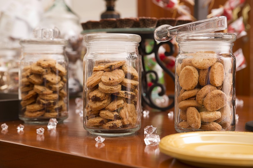 Glass cookie jars on a dessert table at a party.