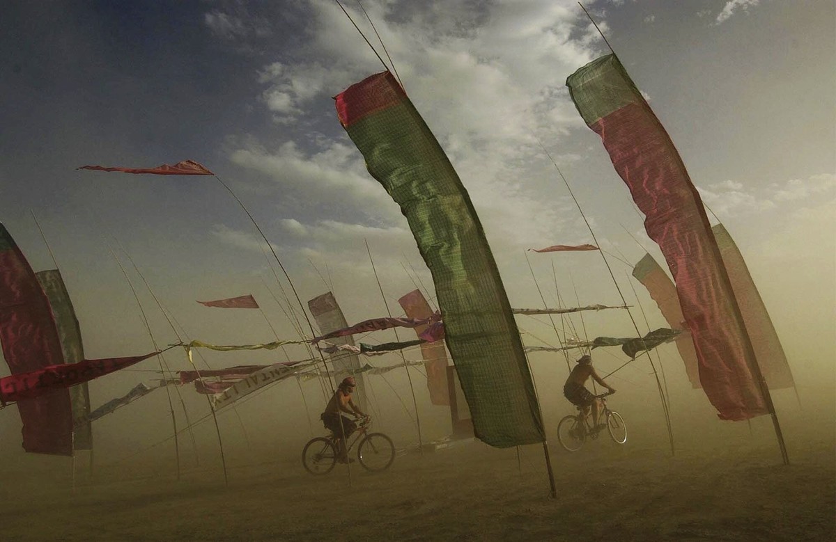FILE - Bicyclists make their way through an art installation at the Burning Man counter-culture arts festival, Wednesday, Sept. 1, 2004, in Gerlach, Nev. Burning Man organizers don't foresee majo ...