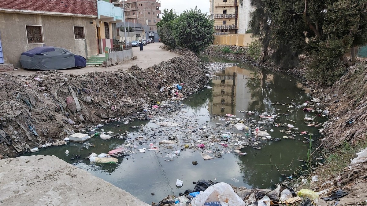 Dirty street and channel with water in Egypt