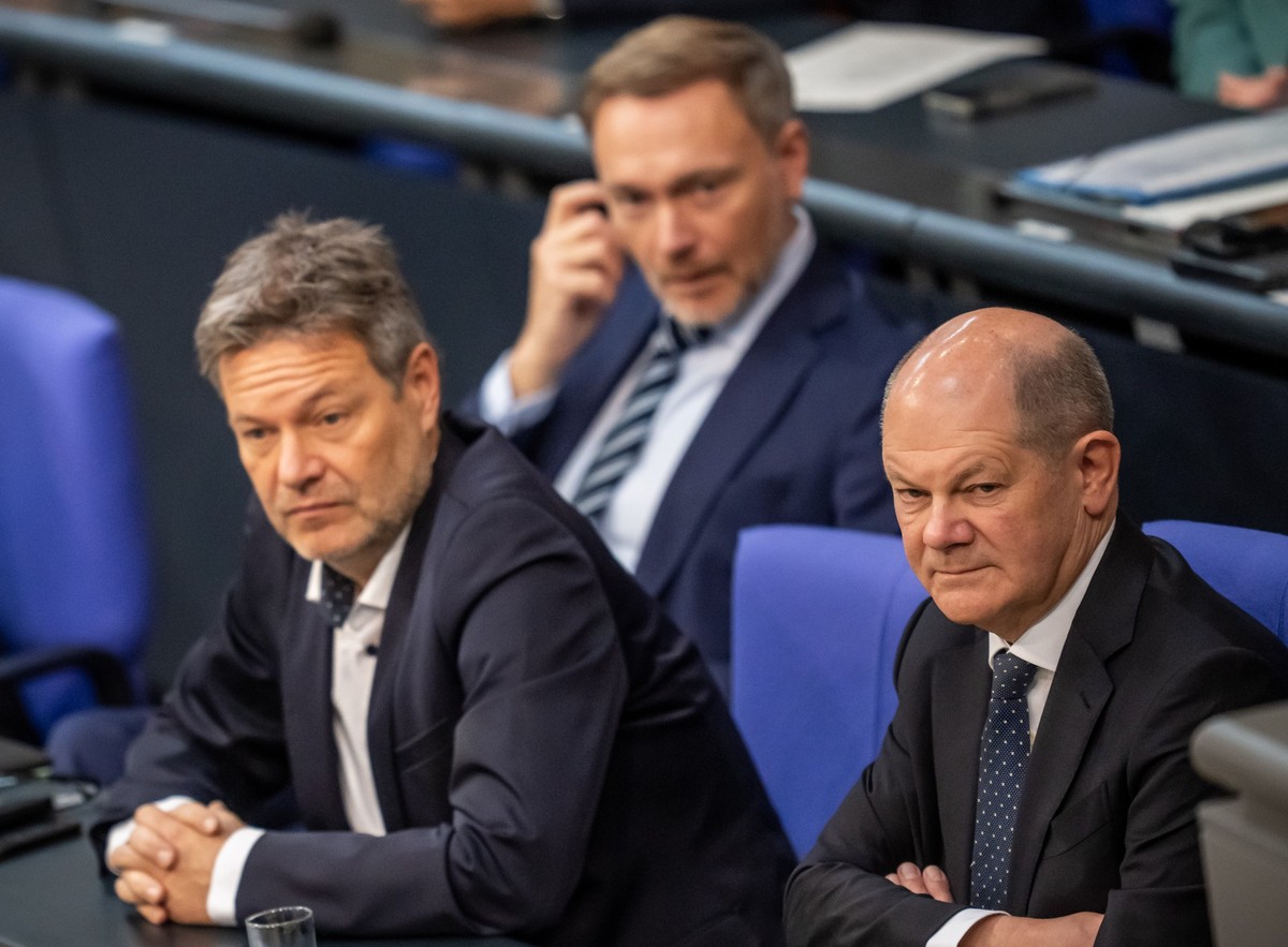 ARCHIV - 28.11.2023, Berlin: Bundeskanzler Olaf Scholz (SPD, r), verfolgt neben Robert Habeck (Bündnis 90/Die Grünen, l), Bundesminister für Wirtschaft und Klimaschutz, und Christian Lindner (FDP), Bu ...