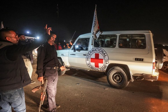 24.11.2023, Pal�stinensische Gebiete, Rafah: Ein Fahrzeug des Roten Kreuzes, in dem vermutlich Geiseln transportiert werden, die w�hrend des Angriffs auf Israel am 7. Oktober 2023 von Hamas-K�mpfern e ...