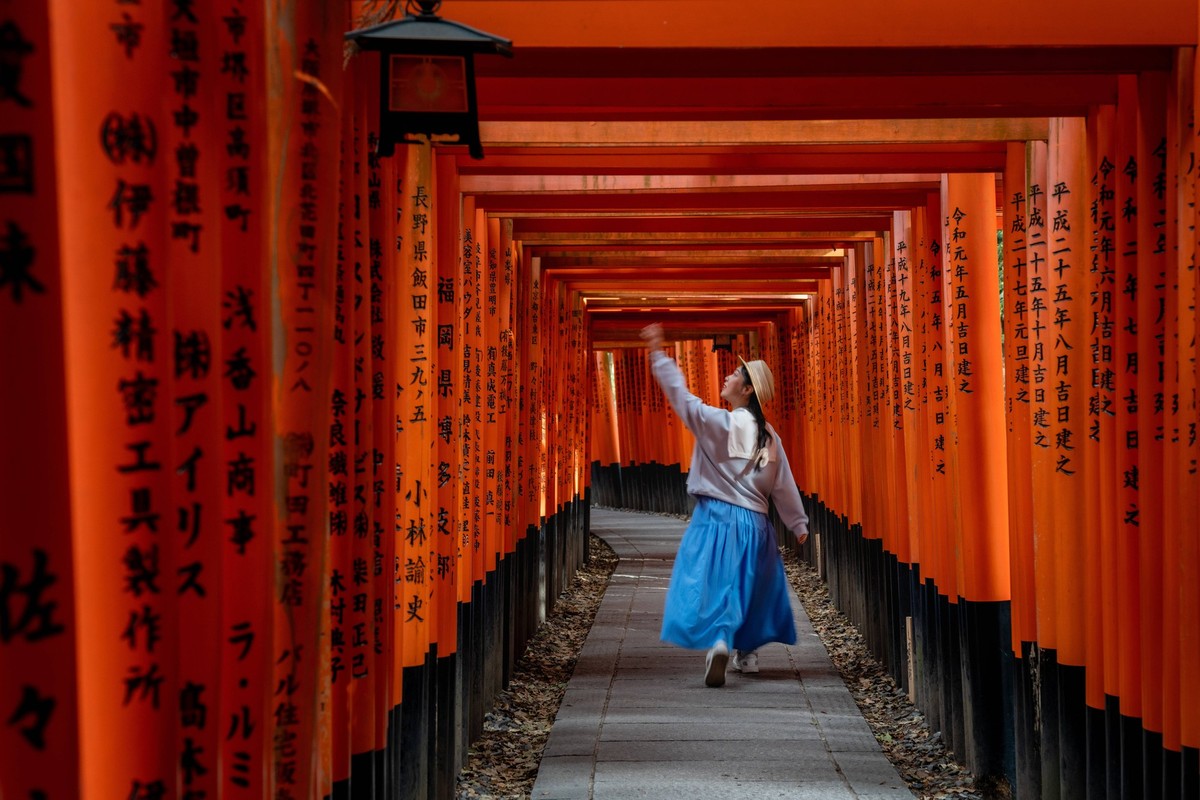 Japan s symbol of wishes and gratitude: Fushimi Inari-taisha KYOTO, JAPAN - MAY 02: A visitor walks at the Fushimi Inari-taisha, famous for its thousands of torii gates, in Fushimi-ku, Kyoto, Japan on ...