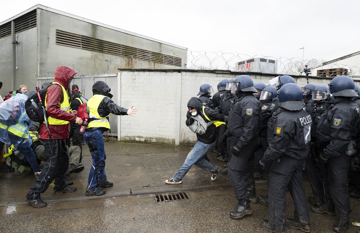 29.11.2025, Hessen, Gießen: Polizisten stehen in der Nähe der Versammlungshalle und sperren Demonstranten den Zugang. Mehrere Tausend Demonstranten protestierten am Samstag gegen die Neugründung einer ...