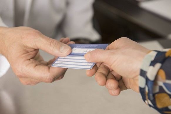 Patientin gibt Arzt die Kassenkarte