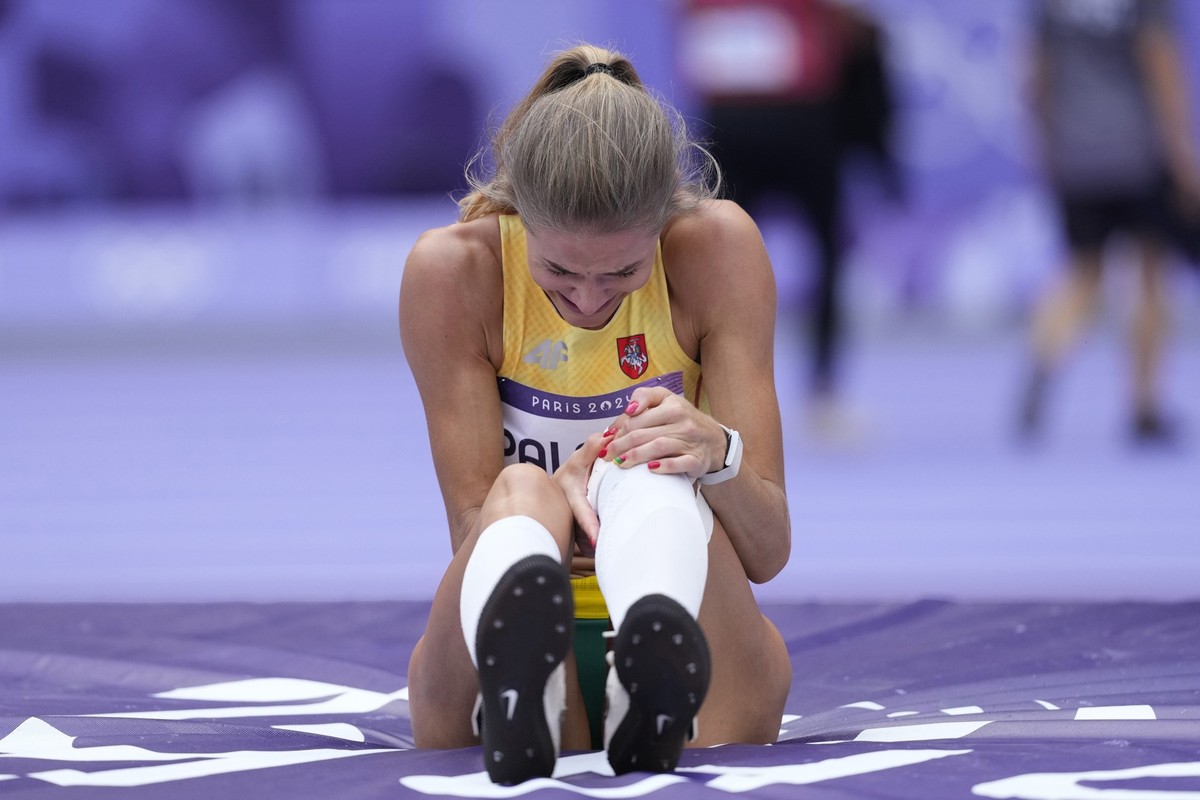 Airine Palsyte, of Lithuania, grimaces after getting injured during the women's high jump qualification at the 2024 Summer Olympics, Friday, Aug. 2, 2024, in Saint-Denis, France. (AP Photo/Bernat ...
