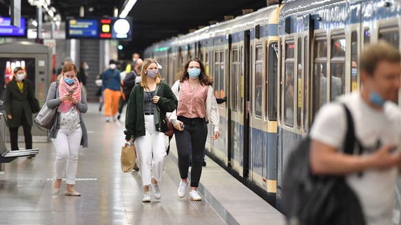 Maskenpflicht im oeffentlichen Personennahverkehr.
U-Bahn Muenchen am 16.05.2020.
Auf dem Bahnsteig gehen Fahrgaeste 
zum Zug -alle tragen Masken.
Mund-Nasen-Schutz.Munschutz,Maske,
OEPNV,oeffentliche ...