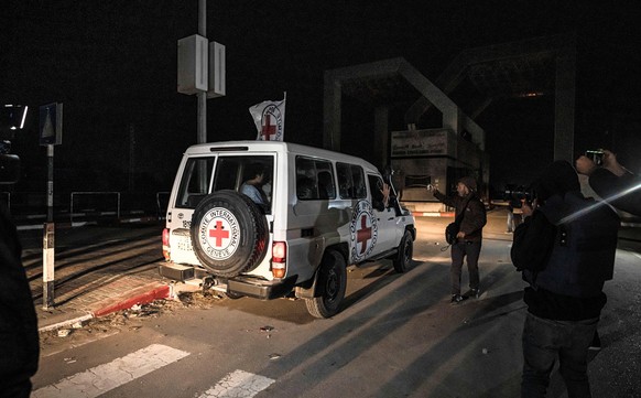 25.11.2023, Palästinensische Gebiete, Rafah: Ein Fahrzeug des Roten Kreuzes mit von der islamistischen Hamas im Gazastreifen freigelassenen Geiseln fährt Richtung Grenzübergang zwischen dem Gazastreif ...