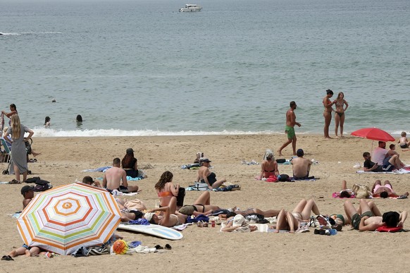 16.06.2023, Frankreich, Biarritz: Menschen sonnen sich an einem Strand im Südwesten Frankreichs. Die Temperaturen sind die ganze Woche über gestiegen, und es wird erwartet, dass sie über 30 Grad Celsi ...