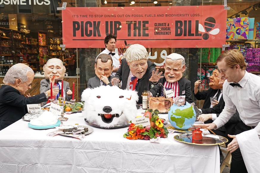 Cop26 - Glasgow. Actors dressed in masks depicting current world leaders, dine at a banquet of environmental and climate degradation during a performance on Buchanan Street, during the Cop26 summit in ...