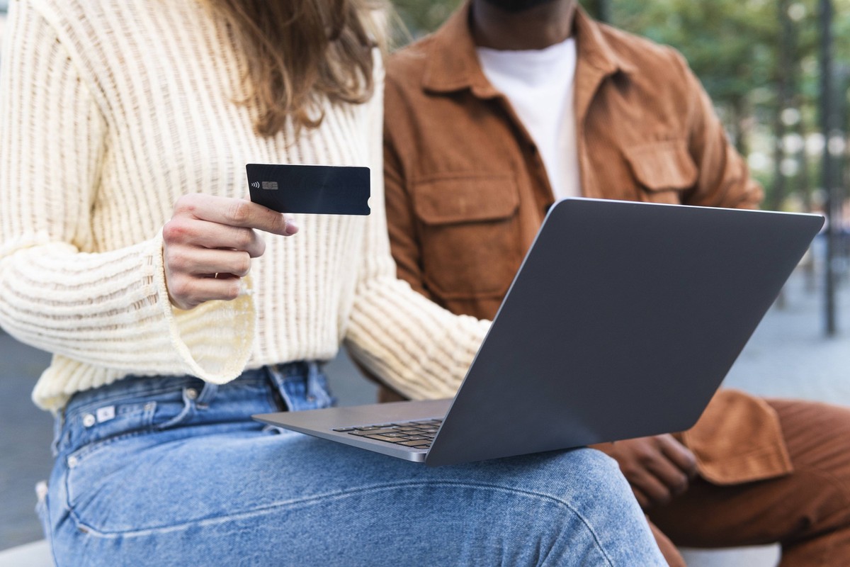 Woman with credit card using laptop sitting by boyfriend model released, Symbolfoto, PNAF06434