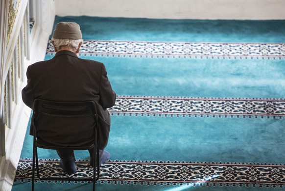 BERLIN, GERMANY - OCTOBER 03: An elderly Muslim man is seen sitting on a chair during midday prayers at Sehitlik mosque, which is mostly Turkish, on Open Mosque Day on October 3, 2017 in Berlin, Germa ...