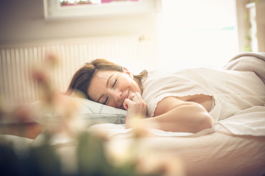 Young woman waking up in bed. Space for copy.