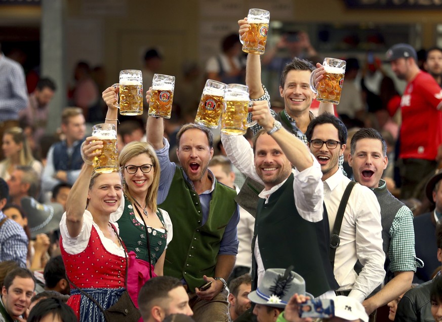 FILE - Visitors lift glasses of beer during the opening of the 186th &#039;Oktoberfest&#039; beer festival in Munich, Germany, on Sept. 21, 2019. The Oktoberfest is on tap again in Germany after a two ...