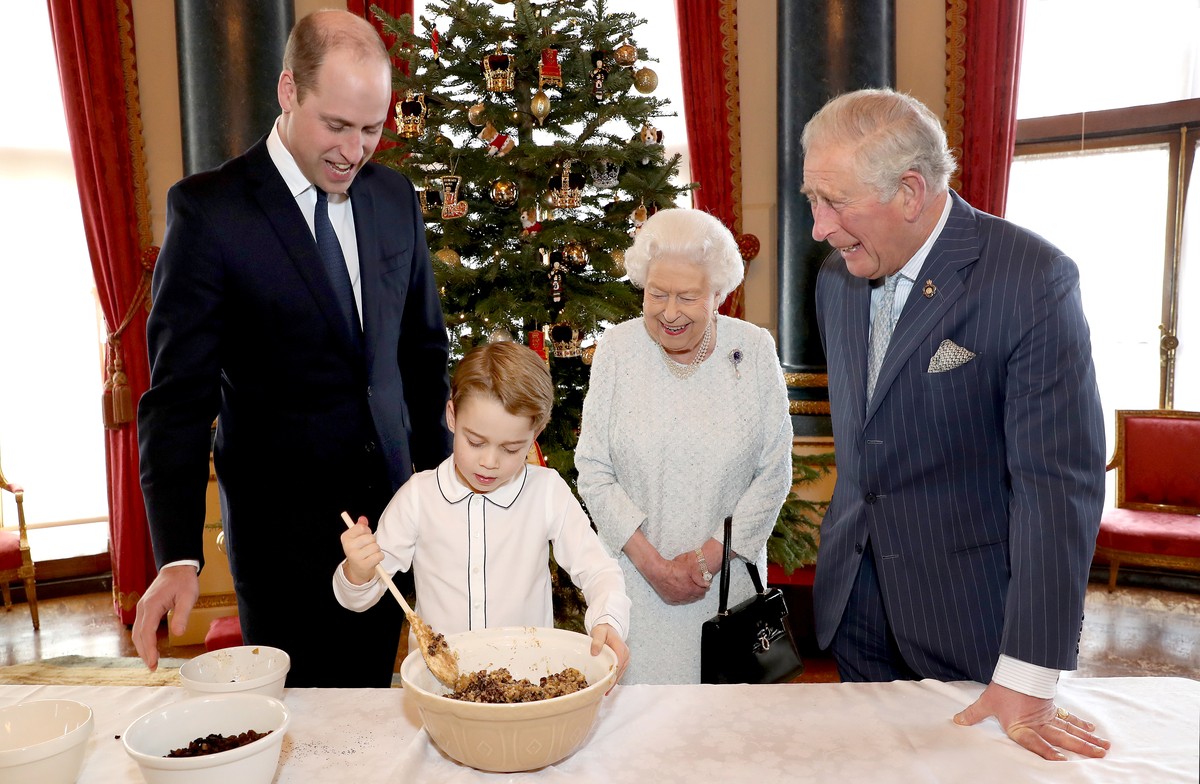 An undated photograph released on December 21, 2019 by Buckingham Palace shows Britain's Queen Elizabeth, Prince Charles, Prince William, and Prince George preparing special Christmas puddings in ...