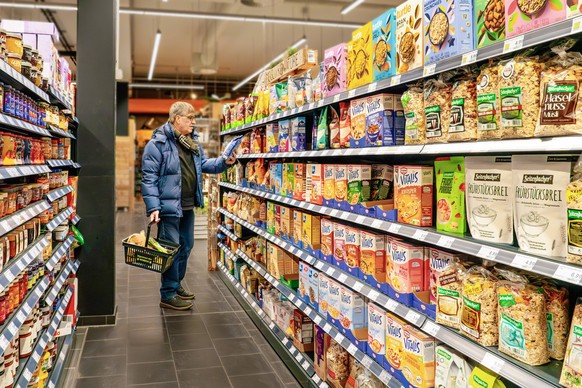 Kunde am Müsli-Regal im Supermarkt, München, Januar 2024 Deutschland, München, Januar 2024, Kunde am Müsli-Regal im Supermarkt, große Auswahl an Frühstücks-Cerealien, Lebensmittel aus dem Supermarkt,  ...