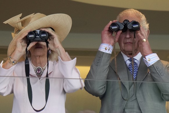 dpatopbilder - 21.06.2023, Großbritannien, Ascot: Königin Camilla und König Charles III. beobachten mit einem Fernglas ein Rennen am zweiten Tag des Royal Ascot Pferderennens auf der Pferderennbahn As ...