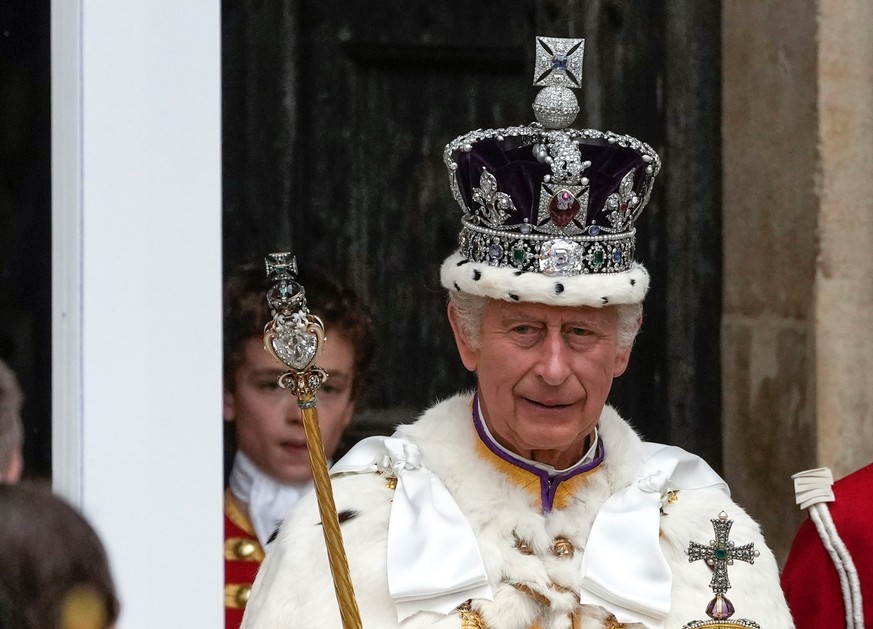 06.05.2023, Großbritannien, London: Großbritanniens König Charles III. verlässt nach der Krönungszeremonie mit der Imperial State Crown, einem Zepter und dem Reichsapfel die Westminster Abbey. Zur Krö ...