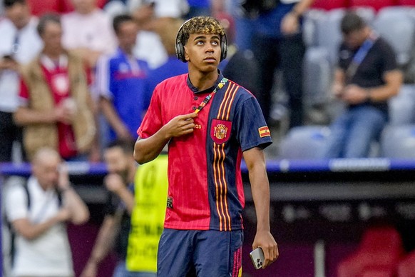 Lo spagnolo Lamine Yamal indossa le cuffie prima della semifinale tra Spagna e Francia al campionato di calcio Euro 2024 a Monaco, Germania, martedì 9 luglio 2024. (AP Photo/Hassan Ammar)