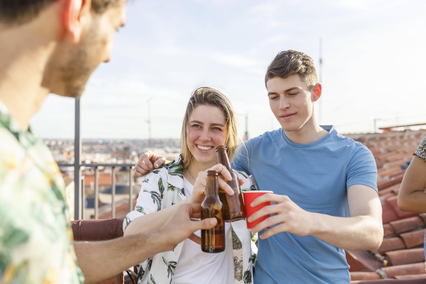 Male and female friends toasting drinks on terrace during weekend party model released Symbolfoto property released IFRF00983