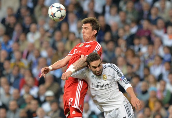 Munich's Mario Mandzukic (l) and Daniel Carvajal of Real Madrid vie for the ball during the UEFA Champions League semi final first leg soccer match between Real Madrid and FC Bayern Munich at Santiago ...