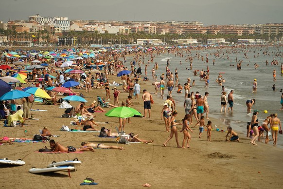 10.08.2023, Spanien, Valencia: Badegäste am Strand von Malvarrosa in Valencia. Der nationale Wetterdienst Aemet hat für mehrere Gebiete des Landes die Alarmstufe Rot wegen hoher Temperaturen ausgerufe ...