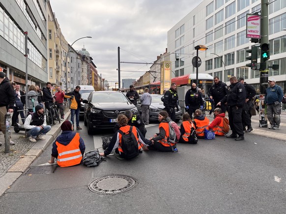 Festgeklebt am Asphalt lösten Aktivist:innen einen Stau in der Berliner Innenstadt aus.
