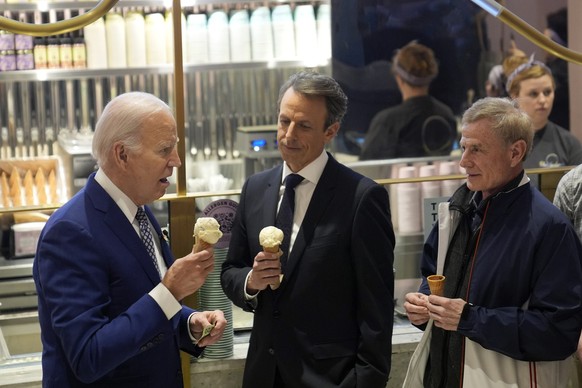 President Joe Biden talks with Seth Meyers, center, as he visits Van Leeuwen Ice Cream Monday, Feb. 26, 2024, in New York, as Seth Meyers watches. (AP Photo/Evan Vucci)