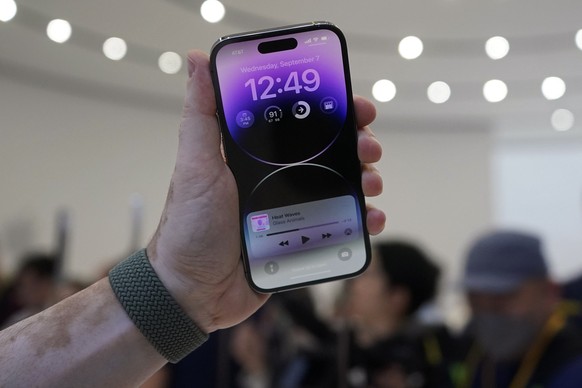 07.09.2022, USA, Cupertino: Eine Person hält ein neues iPhone 14 Pro bei einer Apple-Veranstaltung auf dem Campus des Apple-Hauptquartiers. Foto: Jeff Chiu/AP/dpa +++ dpa-Bildfunk +++