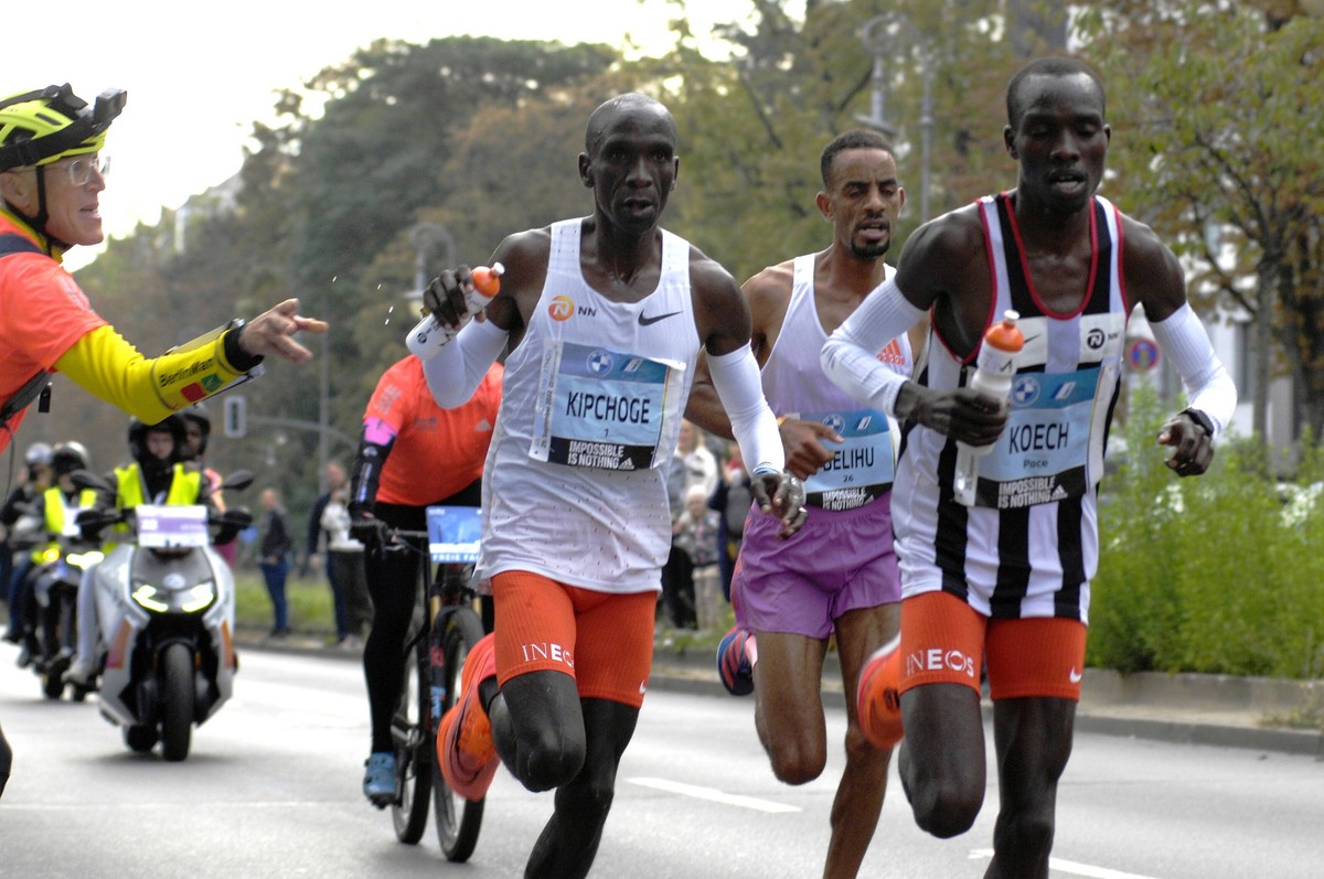 Berlin-Marathon 2022, Eliud Kipchoge Kenia erhält Verpflegung von Betreuer Claus-Henning Schulke bei km 17,5. *** Berlin Marathon 2022, Eliud Kipchoge Kenya food supply by Claus-Henning Schulke at km ...