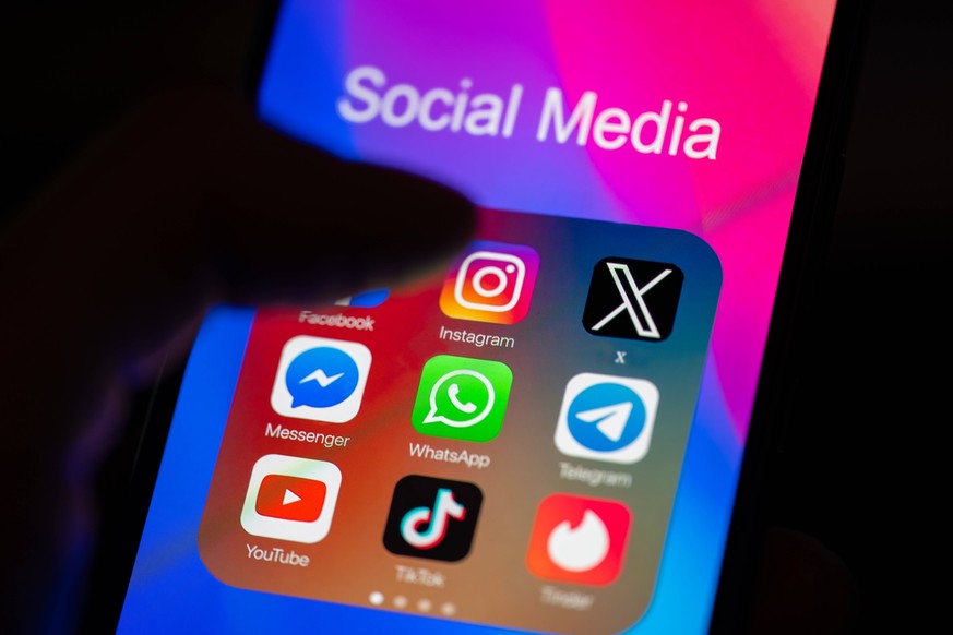Social Media App - Photo Illustration A close-up of a finger is pointing to the Instagram mobile app on a smartphone screen, which is displayed alongside other apps including Facebook, WhatsApp, Teleg ...