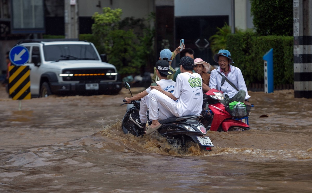 September 25, 2024, Chiang Mai, Thailand: Motorcyclists are riding on a flooded street in the Chang Khlan area due to the Ping River overflowing into urban areas after continuous rainfall in Chiang Ma ...