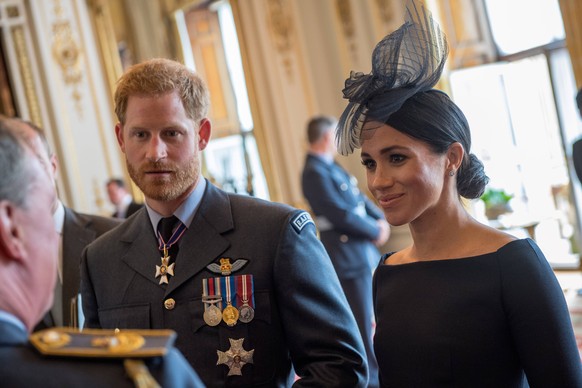 Britain s Prince Harry, Duke of Sussex and Meghan, Duchess of Sussex gestures attend a reception to mark the centenary of the Royal Air Force (RAF) at Buckingham Palace in central London on July 10, 2 ...