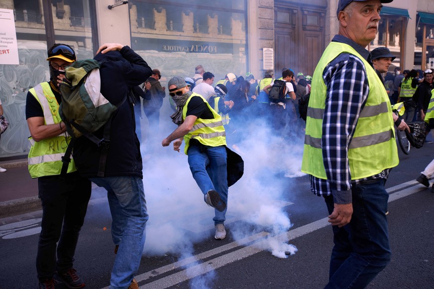April 20, 2019 - Toulouse, France - A Yellow Vest kicks back to riot police a tear gas canister as others run away.For the Act 23 of the Yellow Vest protest, thousands of protesters called Gilets jaun ...