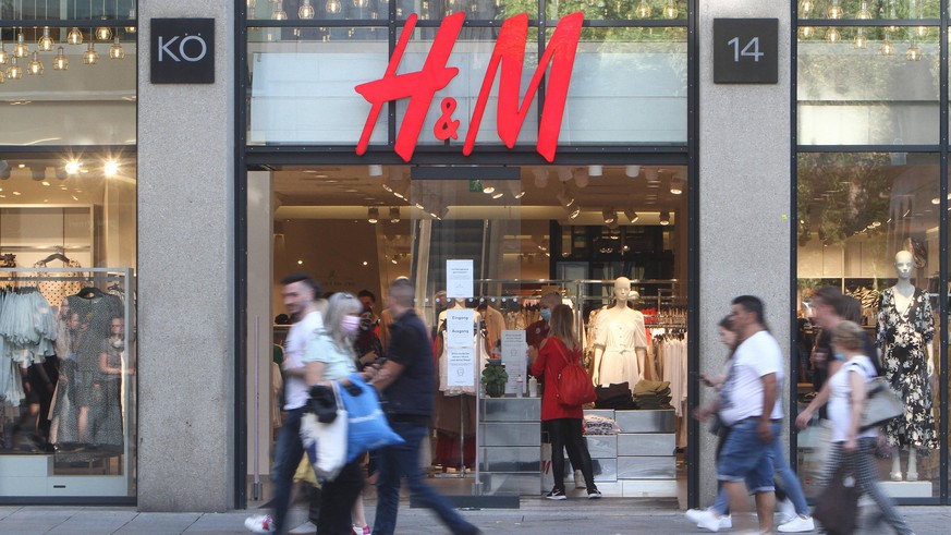 Passanten gehen an einer H &amp; M Hennes Mauritz Filiale in der Fußgängerzone und Einkaufsstraße Königstraße in der Innenstadt von Stuttgart vorbei, Baden Württemberg, Deutschland *** Passers-by walk ...