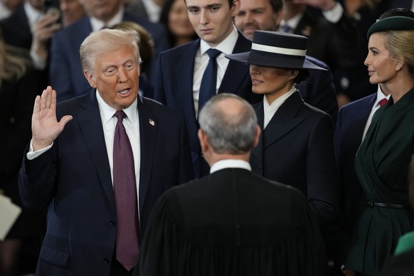 Donald Trump is sworn in as the 47th president of the United States by Chief Justice John Roberts as Melania Trump holds the Bible during the 60th Presidential Inauguration in the Rotunda of the U.S.  ...