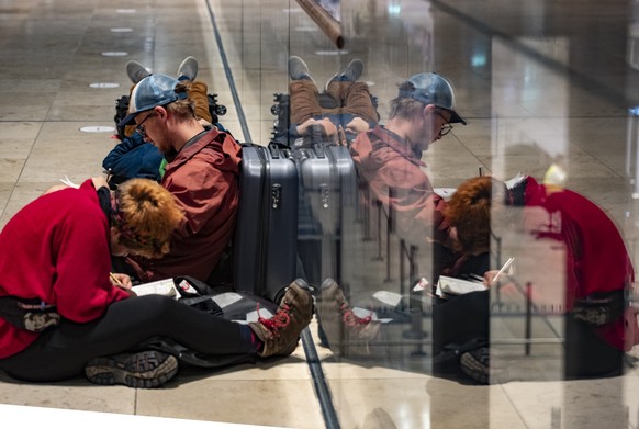 Reisende warten am Flughafen BER auf die Öffnung der Check-in-Schalter.