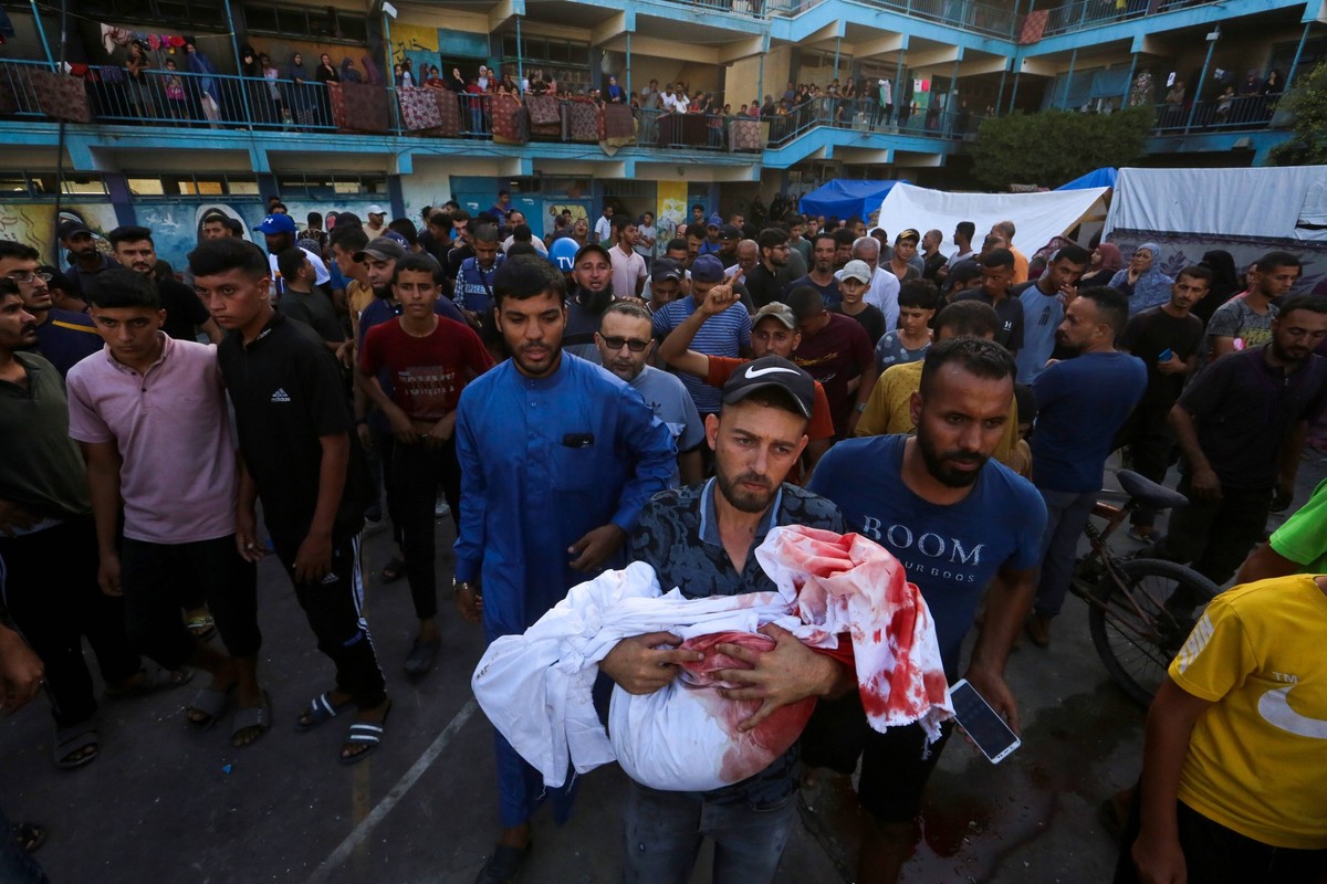 Palestinians stand in the courtyard of a school after an Israeli air strike hit the site, in Nuseirat in the central Gaza Palestinians stand in the courtyard of a school after an Israeli air strike hi ...