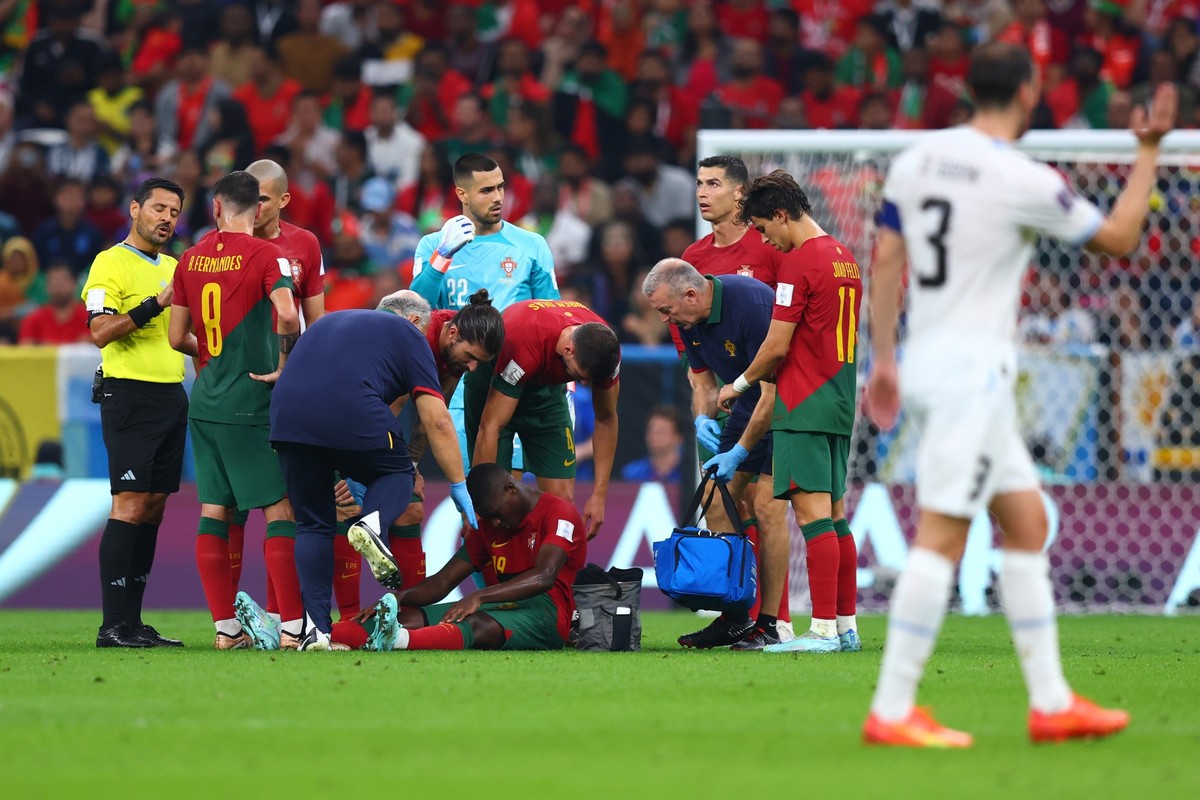 28.11.2022, Katar, Lusail: Fu�ball, WM 2022 in Katar, Portugal - Uruguay, Vorrunde, Gruppe H, Spieltag 2, Lusail Stadion, Portugals Nuno Mendes sitzt auf dem Rasen und wird behandelt. Foto: Tom Weller ...